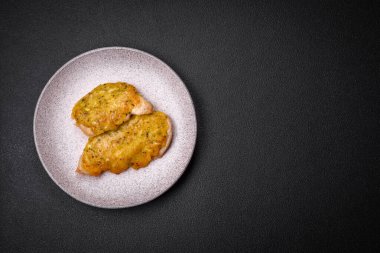 Dijon hardalıyla kızartılmış lezzetli et. Tuz, baharat ve otlarla birlikte koyu beton bir arka planda.