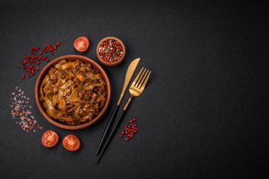 Sebzeli, mantarlı, tuzlu ve baharatlı lezzetli Asya udonu tabağı koyu beton arka planda.