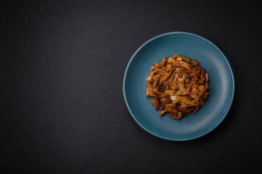 Sebzeli, mantarlı, tuzlu ve baharatlı lezzetli Asya udonu tabağı koyu beton arka planda.