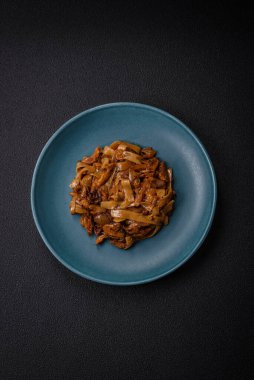 Sebzeli, mantarlı, tuzlu ve baharatlı lezzetli Asya udonu tabağı koyu beton arka planda.