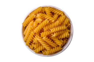 Koyu dokulu arka planda tam tahıllı buğday çeşitlerinden ham fusilli makarna.