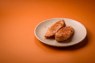 Lezzetli taze ızgara tavuk filetosu, esrarlı baharatlar ve çimento kaplı otlar. Ateşte pişirilmiş bir tabak.