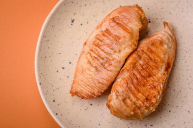 Lezzetli taze ızgara tavuk filetosu, esrarlı baharatlar ve çimento kaplı otlar. Ateşte pişirilmiş bir tabak.