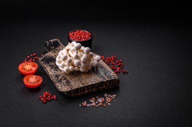 Arka planda tuz ve baharatlı küçük, yenilebilir kayın mantarları. Asya yemekleri için malzemeler