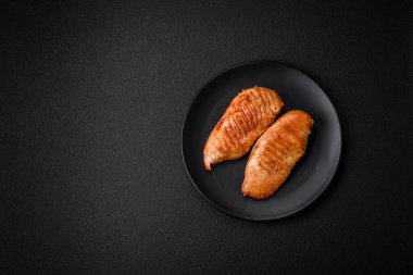 Lezzetli taze ızgara tavuk filetosu, esrarlı baharatlar ve çimento kaplı otlar. Ateşte pişirilmiş bir tabak.