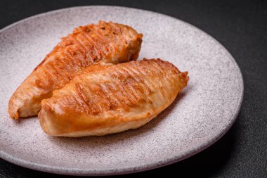 Lezzetli taze ızgara tavuk filetosu, esrarlı baharatlar ve çimento kaplı otlar. Ateşte pişirilmiş bir tabak.