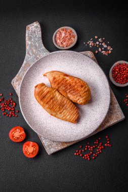 Lezzetli taze ızgara tavuk filetosu, esrarlı baharatlar ve çimento kaplı otlar. Ateşte pişirilmiş bir tabak.