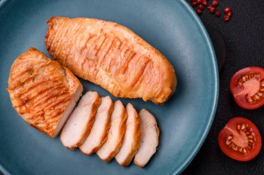 Lezzetli taze ızgara tavuk filetosu, esrarlı baharatlar ve çimento kaplı otlar. Ateşte pişirilmiş bir tabak.