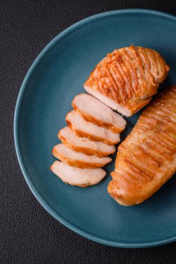 Lezzetli taze ızgara tavuk filetosu, esrarlı baharatlar ve çimento kaplı otlar. Ateşte pişirilmiş bir tabak.