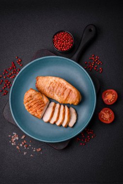 Lezzetli taze ızgara tavuk filetosu, esrarlı baharatlar ve çimento kaplı otlar. Ateşte pişirilmiş bir tabak.