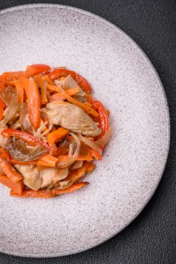 Tavuk ve hindi ile nefis taze yahni ya da tatlı biber dilimleri ve tuz ve baharatlı havuç ile koyu beton arka planda.