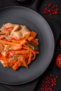 Tavuk ve hindi ile nefis taze yahni ya da tatlı biber dilimleri ve tuz ve baharatlı havuç ile koyu beton arka planda.