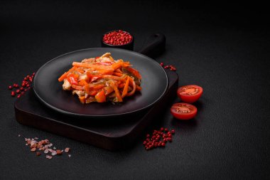 Tavuk ve hindi ile nefis taze yahni ya da tatlı biber dilimleri ve tuz ve baharatlı havuç ile koyu beton arka planda.