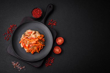 Tavuk ve hindi ile nefis taze yahni ya da tatlı biber dilimleri ve tuz ve baharatlı havuç ile koyu beton arka planda.