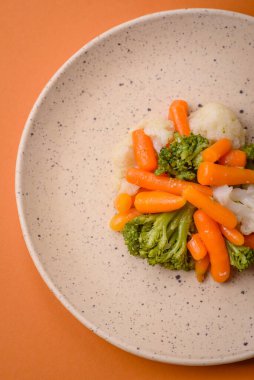 Lezzetli taze sebzeler brokoli, karnabahar, tuz, baharat ve otlarla pişirilmiş havuç.