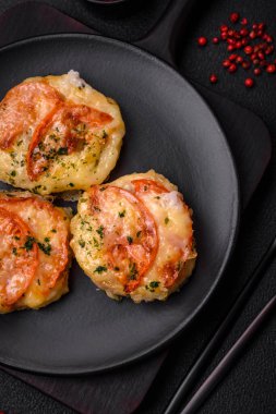 Peynirli, domatesli, tuzlu, baharatlı ve çimento kaplı lezzetli balık filetosu.