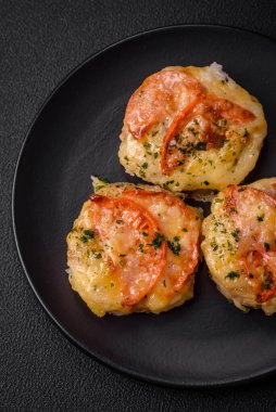 Peynirli, domatesli, tuzlu, baharatlı ve çimento kaplı lezzetli balık filetosu.