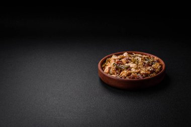 Lezzetli Asya yemeği udonu acı biber, yeşil fasulye, baharat ve otlar seramik tabakta koyu beton arka planda.