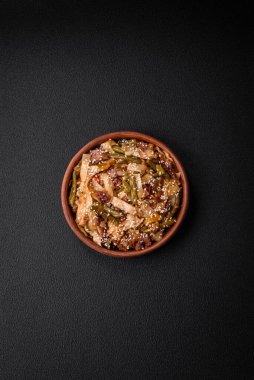 Lezzetli Asya yemeği udonu acı biber, yeşil fasulye, baharat ve otlar seramik tabakta koyu beton arka planda.