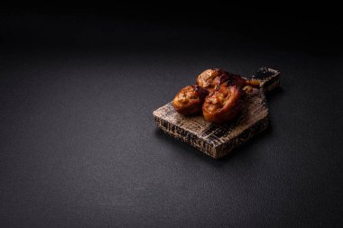 Lezzetli ızgara tavuk bacağı. Baharatlı ve otlu teriyaki soslu. Koyu beton arka planda.