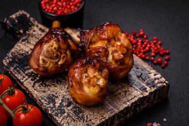 Lezzetli ızgara tavuk bacağı. Baharatlı ve otlu teriyaki soslu. Koyu beton arka planda.