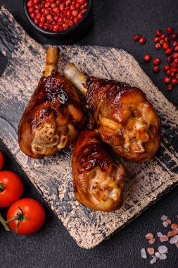 Lezzetli ızgara tavuk bacağı. Baharatlı ve otlu teriyaki soslu. Koyu beton arka planda.