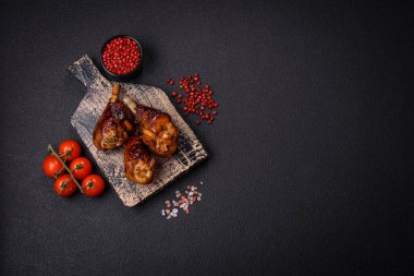 Lezzetli ızgara tavuk bacağı. Baharatlı ve otlu teriyaki soslu. Koyu beton arka planda.