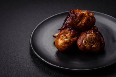 Lezzetli ızgara tavuk bacağı. Baharatlı ve otlu teriyaki soslu. Koyu beton arka planda.