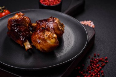 Lezzetli ızgara tavuk bacağı. Baharatlı ve otlu teriyaki soslu. Koyu beton arka planda.