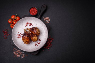 Lezzetli ızgara tavuk bacağı. Baharatlı ve otlu teriyaki soslu. Koyu beton arka planda.