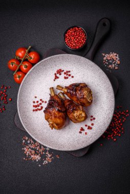 Lezzetli ızgara tavuk bacağı. Baharatlı ve otlu teriyaki soslu. Koyu beton arka planda.