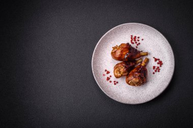 Lezzetli ızgara tavuk bacağı. Baharatlı ve otlu teriyaki soslu. Koyu beton arka planda.