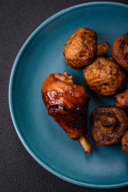 Lezzetli ızgara tavuk bacağı. Baharatlı ve otlu teriyaki soslu. Koyu beton arka planda.