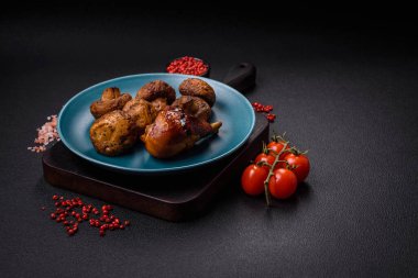 Lezzetli ızgara tavuk bacağı. Baharatlı ve otlu teriyaki soslu. Koyu beton arka planda.