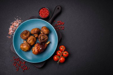 Lezzetli ızgara tavuk bacağı. Baharatlı ve otlu teriyaki soslu. Koyu beton arka planda.