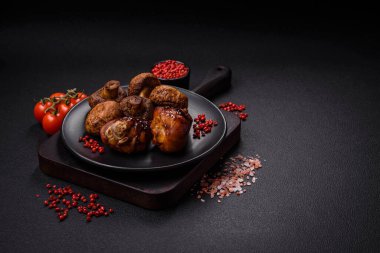 Lezzetli ızgara tavuk bacağı. Baharatlı ve otlu teriyaki soslu. Koyu beton arka planda.