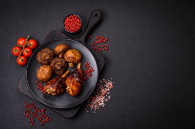 Lezzetli ızgara tavuk bacağı. Baharatlı ve otlu teriyaki soslu. Koyu beton arka planda.