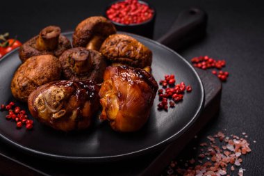 Lezzetli ızgara tavuk bacağı. Baharatlı ve otlu teriyaki soslu. Koyu beton arka planda.