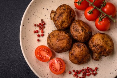 Izgarada pişirilmiş lezzetli sulu şampiyonlar koyu beton arka planda seramik tabakta tuz ve baharatlarla.