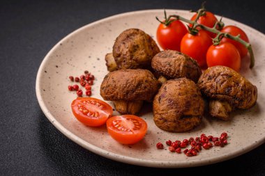 Izgarada pişirilmiş lezzetli sulu şampiyonlar koyu beton arka planda seramik tabakta tuz ve baharatlarla.