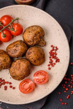 Izgarada pişirilmiş lezzetli sulu şampiyonlar koyu beton arka planda seramik tabakta tuz ve baharatlarla.