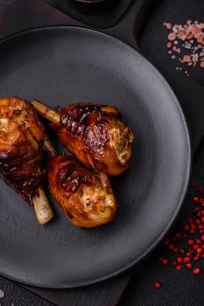 Lezzetli ızgara tavuk bacağı. Baharatlı ve otlu teriyaki soslu. Koyu beton arka planda.