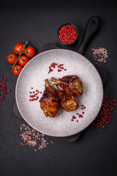 Lezzetli ızgara tavuk bacağı. Baharatlı ve otlu teriyaki soslu. Koyu beton arka planda.