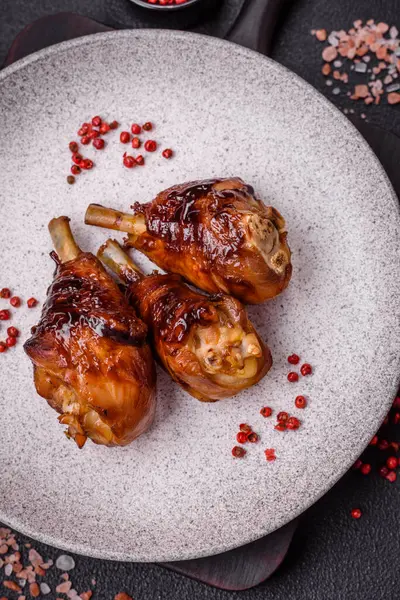 Lezzetli ızgara tavuk bacağı. Baharatlı ve otlu teriyaki soslu. Koyu beton arka planda.