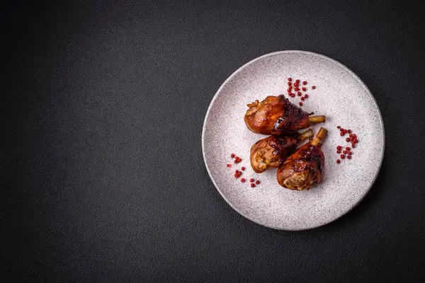 Lezzetli ızgara tavuk bacağı. Baharatlı ve otlu teriyaki soslu. Koyu beton arka planda.