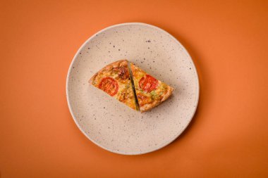 Koyu beton arka planda domates, peynir, tavuk, baharat ve bitkilerle nefis kiş.