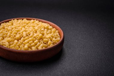 Koyu beton arka planda tuz ve baharatlı buğdaydan lezzetli ditali makarna.