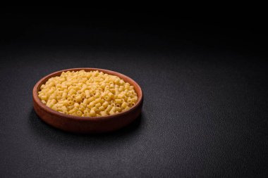 Koyu beton arka planda tuz ve baharatlı buğdaydan lezzetli ditali makarna.