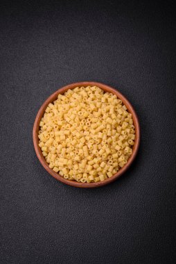 Koyu beton arka planda tuz ve baharatlı buğdaydan lezzetli ditali makarna.