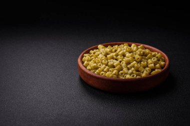 Koyu beton arka planda tuz ve baharatlı buğdaydan lezzetli ditali makarna.